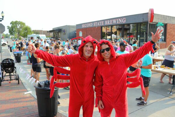 Ty Burke and Tony Pollastrini, The Accel Group employees, in crawfish costumes in front of Second State Brewing in Cedar Falls