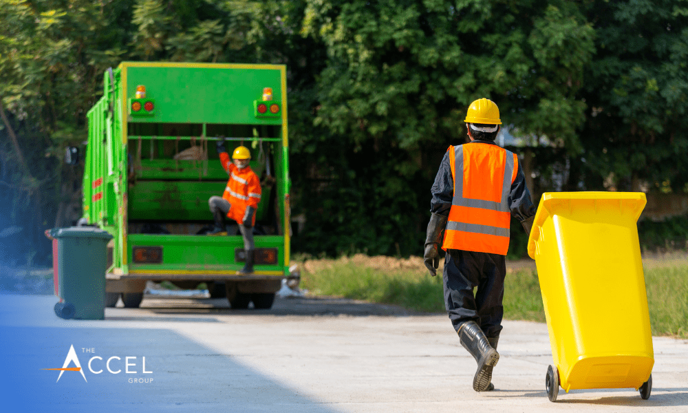 An image of two men with a garbage truck, garbage truck, and The Accel Group's logo