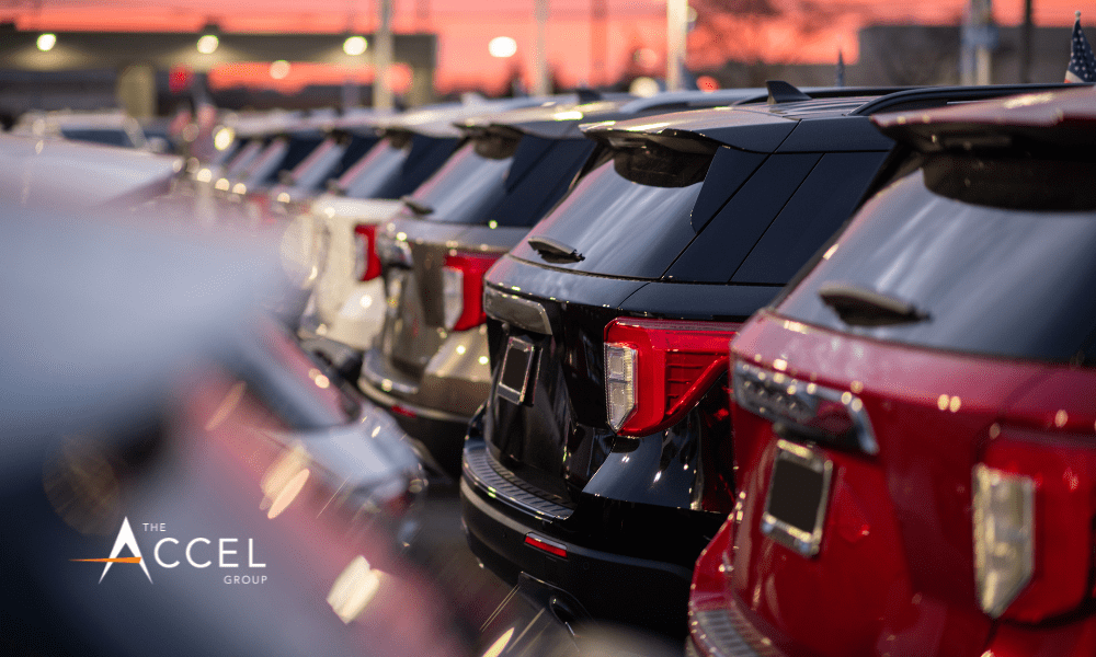 An image of a line of cars at a dealership with The Accel Group logo in the corner